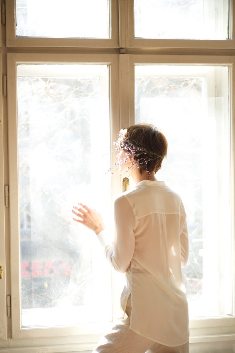 žena gleda kroz prozor