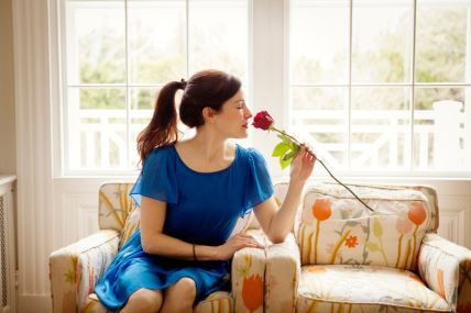 žena sjedi, miriše cvijet