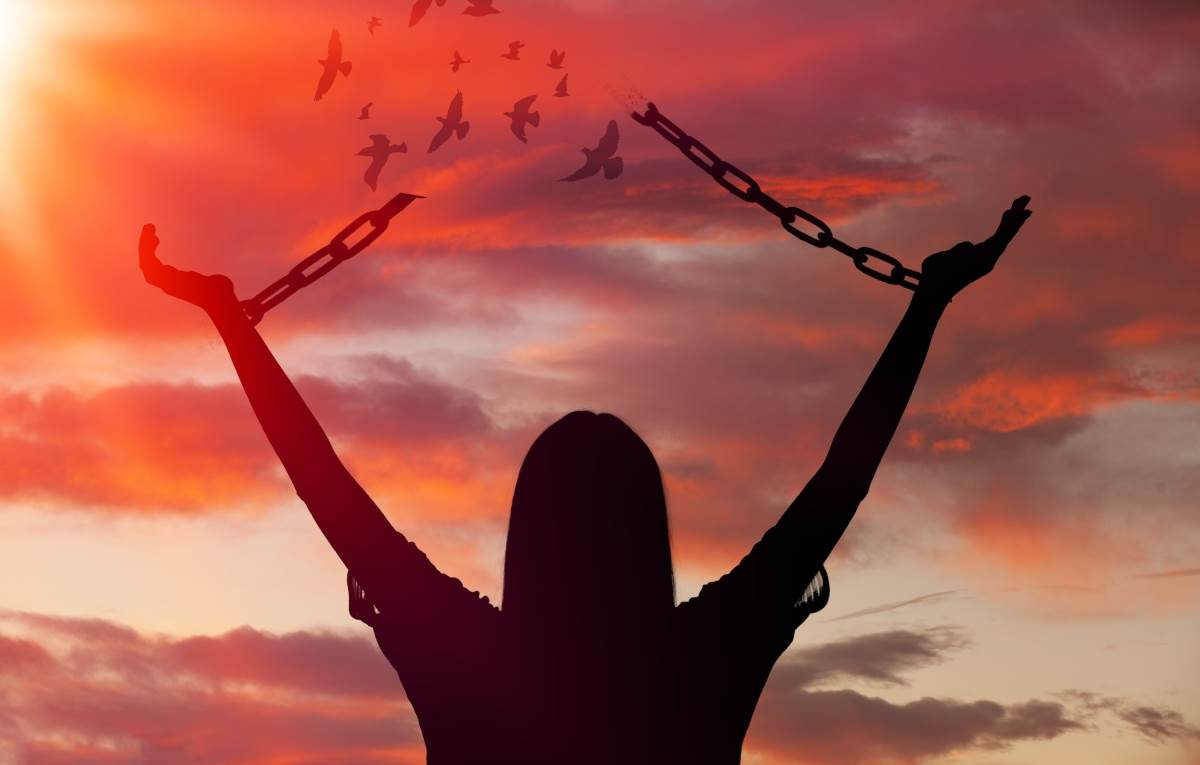 рука держит древний амулет на фоне заката